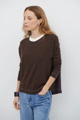 Remera de manga larga con diseño bicolor, presentando un frente en tono marrón oscuro y una espalda en tono violeta oscuro. Posee cuello redondo en color crema con textura acanalada y costuras decorativas visibles en color claro.