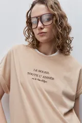 Remera blanca de silueta amplia y calce relajado, confeccionada en tela suave y liviana, con cuello redondo, mangas cortas con vuelta y hombros caídos. Cuenta con un delicado bordado frontal en color azul con la inscripción "LE SOLEIL TOUTE L'ANNÉE sur la Côte d'Azur".