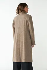 Tapado largo color beige confeccionado en lana, con cuello con solapa, manga larga, forrado, con bolsillos y cierre frontal con botones. Tela 100% lana fina sin teñir, diseñada exclusivamente por Don Baez. Hecho 100% en Uruguay.