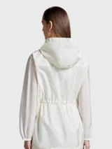 Chaqueta impermeable Moncler modelo Filira, color gris claro, con capucha, cierre frontal con cremallera y cordón ajustable en la cintura.