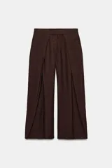 Pantalón de tiro medio color marrón oscuro, con detalle de pinzas marcadas en el delantero y pierna ancha y fluida.