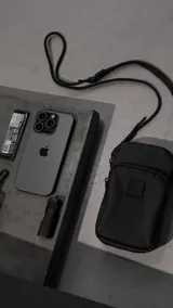 Mini bag o portacelular de formato vertical, confeccionada en cordura waterproof de alta resistencia. Cuenta con dos compartimentos con cierres reforzados y cordón de alta densidad ajustable mediante mosquetones metálicos para usar cruzado.