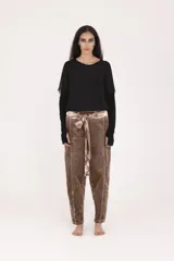 Pantalón de corte baggy y tiro alto, color marrón con efecto desgastado. Presenta costuras verticales marcadas, cintura elástica con cinturón de tela integrado y ajuste holgado en las piernas.