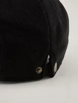 Boina de estilo clásico color negro, confeccionada en tejido de punto acanalado. Presenta una etiqueta rectangular con el logo de la marca Benson & Thomas en el lateral.