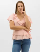 Blusa de satén color rosado con acabado texturizado, escote en V con volados, mangas cortas acampanadas y diseño péplum de doble nivel en la parte inferior.