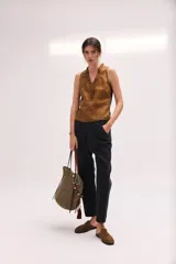 Pantalón de denim negro, tiro bajo y calce relajado, con cierre frontal de botones visibles y largo al tobillo.
