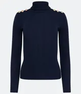 Blusa de punto acanalado en color azul marino, con cuello alto y detalle de botones dorados decorativos en los hombros. Presenta un diseño ajustado de manga larga.