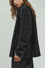 Blazer de corte recto con estampado de cuadros, cuello solapa y manga larga con hombreras. Presenta cierre frontal con botones ocultos bajo solapa y bolsillos delanteros con solapa.