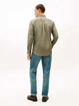 Camisa de manga larga Tommy Hilfiger de corte regular, color verde militar, con cuello abotonado, cierre frontal de botones, bolsillo de parche en el pecho con el logo bordado de la marca y puños con botones.