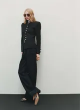 Pantalón de jean de tiro medio color azul oscuro, corte wide leg con cuatro bolsillos y costura ancha en el bajo. Cierre frontal con cremallera y botón.