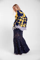Sweater de lana merino tejido a mano con diseño geométrico y figuras de llamas, corte holgado con cuello redondo y flecos decorativos en el ruedo.