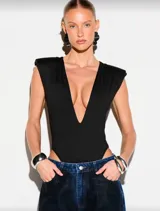 Body negro con escote profundo en V, hombros estructurados y corte high leg. Confeccionado en tela elastizada que se ajusta al cuerpo.