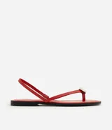 Sandalias planas rojas con diseño de dedo, tiras finas y aplique metalizado decorativo.