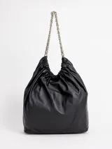 Cartera tipo shopper color negro, confeccionada en 100% cuero, con diseño fruncido en la parte superior, cierre con broche y doble asa de cadena metálica plateada. Incluye bolsillo interior.