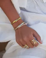 Anillo plateado con textura irregular y diseño rústico.