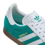 Championes adidas Gazelle edición especial Liverpool FC, color verde esmeralda con las icónicas tres tiras blancas laterales y suela de goma color marrón. Presenta el detalle del nombre del club en letras doradas sobre el lateral.