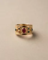 Anillo ancho de bronce con baño de oro, acabado texturizado y diseño decorado con piedras naturales en tonos rojos, verdes y azules.
