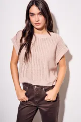 Chaleco sin mangas de tejido de punto color rosado pálido, con textura calada y acabado lurex, corte al cuerpo y cuello redondo.