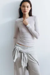 Pantalón deportivo gris claro de corte ancho, con cintura elástica y bolsillos laterales.