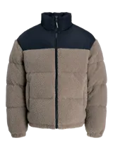 Campera puffer con diseño de bloques de color, combinando tejido teddy en tono arena y paneles negros en los hombros. Presenta cuello alto, cierre frontal y diseño acolchado.