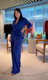 Mono azul de manga 3/4, con escote en V, detalle fruncido en la cintura y pantalón de pierna ancha.