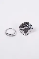 Set de dos anillos de metal color plateado. Uno de ellos presenta un diseño minimalista de banda abierta y el otro destaca por su forma orgánica con textura irregular.