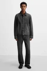 Zapatilla deportiva tipo running de color negro, perteneciente a la colección especial Origins. Presenta una parte superior confeccionada en una combinación de cuero con acabado de gamuza y tejido transpirable. Cuenta con una suela de volumen con diseño irregular y cierre mediante cordones.