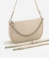 Cartera de mano tipo baguette, de color beige, con cierre superior de cremallera y una cadena decorativa plateada en la parte frontal. Cuenta con una correa larga ajustable y extraíble para usar al hombro o cruzada.