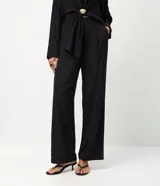 Pantalón de corte recto confeccionado en tejido satinado de viscosa y poliéster. Presenta pliegues delanteros marcados, cintura con trabillas y bolsillo trasero incorporado.