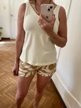 Conjunto de pijama compuesto por musculosa color crema y short estampado con hojas color marrón.