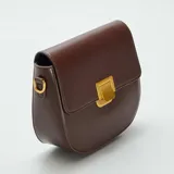 Bolso bandolera marrón con cierre dorado.