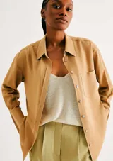 Camisa de manga larga con diseño extragrande y oversize, de color mostaza, con cuello clásico, cierre frontal con botones y bolsillo aplicado en el pecho.