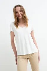 Remera blanca de manga corta, de corte clásico y calce relajado, con escote en V adornado con delicado detalle de broderie.