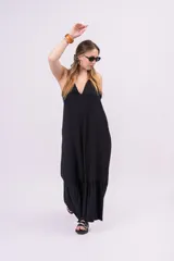 Vestido largo negro de estilo boho-chic, confeccionado en tela liviana con caída fluida, escote halter en V pronunciado y gran volante inferior en el ruedo.