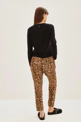 Pantalon de corte holgado con estampado animal print de leopardo, cintura elástica con cordón ajustable y bolsillos laterales.