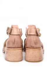 Sandalia de gamuza color beige, con diseño de pulsera al tobillo, hebilla metálica dorada y taco cuadrado de madera.
