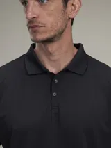 Chomba de piqué negra, de corte clásico, con cuello polo y tapeta de dos botones.