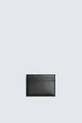 Tarjetero de diseño minimalista en color negro con acabado texturizado. Cuenta con un compartimento principal y dos ranuras para tarjetas.