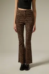 Pantalon de jean con corte flare y tiro alto, estampado con diseño animal print de leopardo en tonos marrones. Cuenta con bolsillos funcionales y ruedo desflecado.