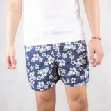 Short de baño azul marino con estampado de flores blancas y grises, con cintura elástica y cordón ajustable.