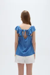 Musculosa amarilla de viscosa, con cuello en V y breteles anchos decorados con volados. Presenta un corte holgado.