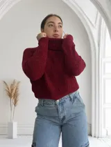 Sweater de punto grueso color bordó, con cuello alto y mangas largas.
