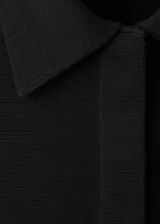 Cardigan de punto negro, de manga larga y cierre frontal con botones. Confeccionado 100% en algodón.