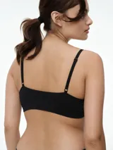 Bralette seamless de microfibra color blanco, con diseño de escote en V, sin relleno y sin aros. Presenta breteles finos ajustables y una banda elástica inferior con textura acanalada.