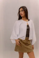 Blusa de lino color blanco, de diseño amplio con mangas murciélago y bordado decorativo en los bordes.