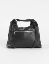 Cartera hobo convertible a mochila, color marrón, confeccionada en cuero sintético. Presenta un diseño con bolsillo frontal con solapa y cierre de hebilla metálica, además de correas ajustables y herrajes plateados.