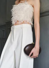 Top de diseño strapless color blanco marfil, con textura de flecos tipo plumas en todo el cuerpo y corte crop.
