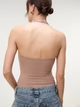 Top halter cropped de tejido rib color beige, con escote redondo pronunciado y espalda descubierta, de calce entallado.