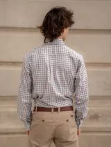 Camisa de corte clásico con estampado de cuadros en tonos rosados y celestes, con cuello abotonado, manga larga y bolsillo frontal con detalle bordado.