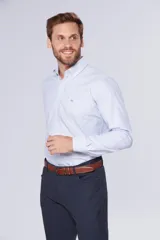 Camisa casual celeste de manga larga con diseño a rayas finas, cuello con botones y bolsillo ojal en el pecho con logo bordado.